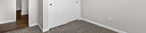 a bedroom with a white door and a door to a closet at Switchback on Platte Apartments, Littleton, 80120