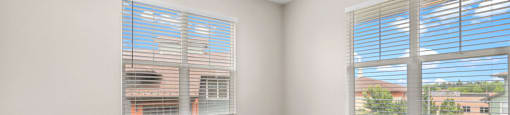 an empty bedroom with two windows and carpeting at Switchback on Platte Apartments, Littleton, CO