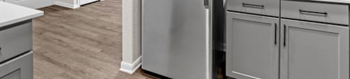 a renovated kitchen with stainless steel refrigerator and white cabinets at Switchback on Platte Apartments, Littleton, Colorado