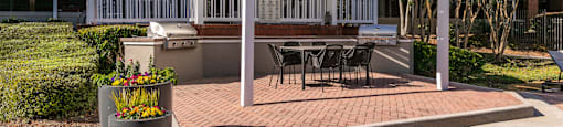 a white pergola on a brick patio with a table and chairs at Briarcliff Apartments, Georgia, 30329