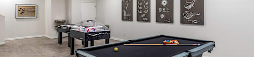 a game room with two pool tables and two foosball