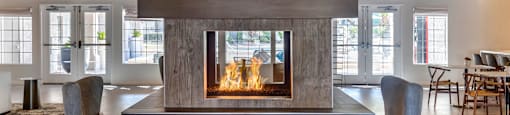 a living room with a fireplace and chairs and a table
