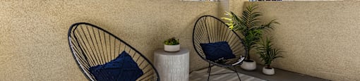 a patio with two chairs and a plant on a balcony at Mirasol Apartments, Las Vegas, NV