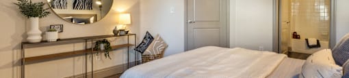 a bedroom with a large white bed and a mirror at Mirasol Apartments, Las Vegas