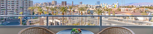 a balcony with two chairs and a table overlooking the city at The Rays at Vegas Towers Apartments, Las Vegas, 89119