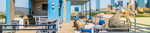 a rooftop patio with tables and chairs and a view of the city at South Side Flats, Dallas, 75215