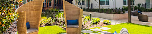 a patio with chairs and a fire pit in front of an apartment building at South Side Flats, Texas, 75215