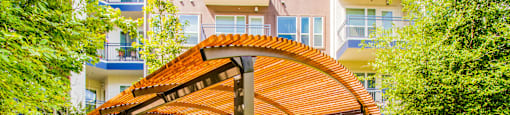 a patio with chairs and a pergola in front of an apartment building at South Side Flats, Dallas, TX, 75215