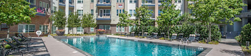 an apartment pool with an apartment building in the background at South Side Flats, Dallas, TX