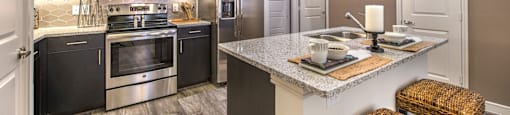 a kitchen with stainless steel appliances and a marble counter top at South Side Flats, Dallas, TX
