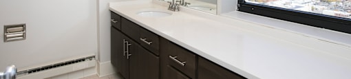 a bathroom with a large window and a sink and mirror at Apartments at Denver Place, Colorado