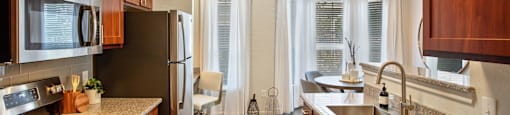 a kitchen with granite counter tops and stainless steel appliances at Volare at the Woodlands, The Woodlands, TX