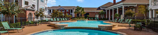 a large swimming pool with a building in the background  at Volare at the Woodlands, The Woodlands, TX, 77384