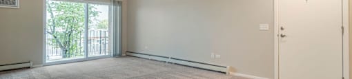 an empty living room with a door to a balcony at Willow Hill Apartments, Justice, IL, 60458