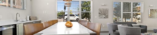 a dining area with a table and chairs and large windows at Ridge at Thornton Station Apartments, Colorado