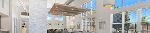 a living room with couches and tables and large windows at Ridge at Thornton Station Apartments, Thornton, 80229