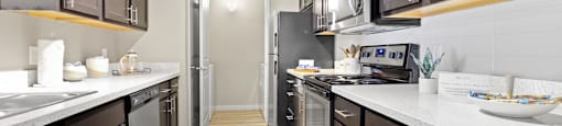 a large kitchen with stainless steel appliances and white counter tops at Ridge at Thornton Station Apartments, Thornton