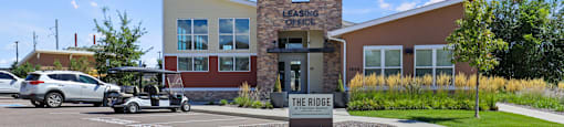 a building with a golf cart parked in front of it at Ridge at Thornton Station Apartments, Colorado, 80229