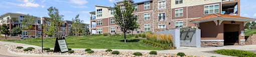an exterior view of an apartment building with a gravel driveway and landscaping at Ridge at Thornton Station Apartments, Thornton, Colorado