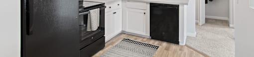 a renovated kitchen with black appliances and white cabinets  at Rosemont Square Apartments, Randolph