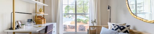 a bedroom with a bed and a desk and a window at Ashford Green, North Carolina