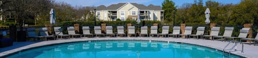 a swimming pool with chairs and a house in the background at Ashford Green, North Carolina, 28262