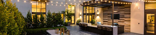 Grill area and table in courtyard at night at Aventine, Hercules, CA, 94547