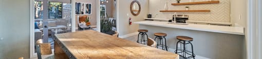 a kitchen with a wooden table and a bar with stools at Bay Village, Vallejo, CA, 94590