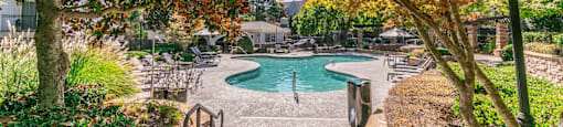 a swimming pool with trees and benches next to it at Deerfield Village, Alpharetta