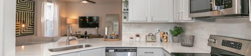 a kitchen with white cabinets and stainless steel appliances at Deerfield Village, Georgia