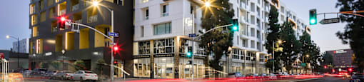 A modern building with a black and white facade stands on a street corner at G12 Apartments, Los Angeles, California