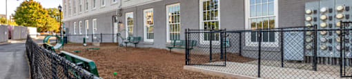 a building with a fenced in yard and a chain link fence at Highland Mill Lofts, Charlotte, NC