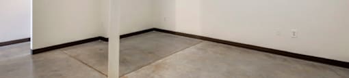 an empty room with white walls and a concrete floor and a pole at Highland Mill Lofts, North Carolina