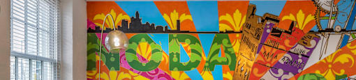 a living room with a colorful mural on the wall at Highland Mill Lofts, North Carolina, 28205