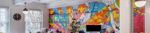 a living room with a table and chairs and a mural on the wall at Highland Mill Lofts, Charlotte, North Carolina