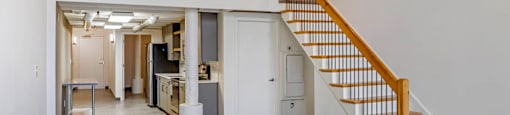 a room with a staircase and a white wall and a ceiling light at Highland Mill Lofts, Charlotte, NC