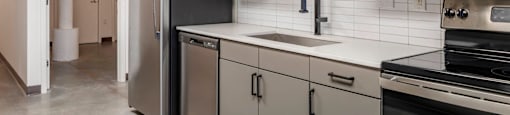 a kitchen with stainless steel appliances and white counter tops at Highland Mill Lofts, North Carolina