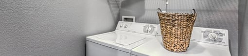a washer and dryer in a laundry room with a rack on the wall at Mirasol Apartments, Las Vegas, Nevada