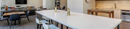 a long white table in the center of a kitchen and living room at North Harbor Tower, Chicago, 60601