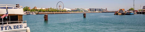 a boat in the water with a ferris wheel in the background at North Harbor Tower, Chicago, 60601