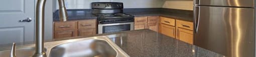 a kitchen with stainless steel appliances and a sink at Ridge at Thornton Station Apartments, Thornton, CO 80229