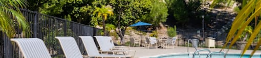 Pool-side lounge chairs at River Oaks in Oceanside, CA