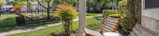 a porch with two chairs and a table and a playground in the background at Sladestone Shadow Creek, Pearland, TX, 77584