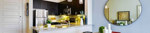a kitchen with a bar and stools and a round table at South Side Flats, Dallas, TX