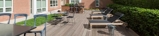 a large patio with tables and chairs in front of an apartment building at Amelia, Quincy, Massachusetts