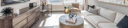 a living room with a large window and a couch and a table at The Elle Apartments, Chicago, 60605