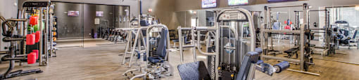 a gym with cardio machines and weights on a wooden floor at Volare at the Woodlands, The Woodlands, 77384