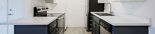 Modern kitchen with black appliances and white cabinets at Aspire Thunderbird, Glendale, Arizona