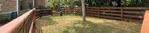 a backyard with a wooden fence and a yard with a tree