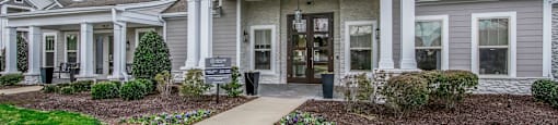 the front of a house with a sidewalk and grass